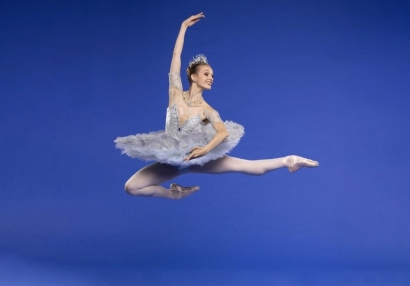 Jennifer Hackbarth performs a jump against a blue background