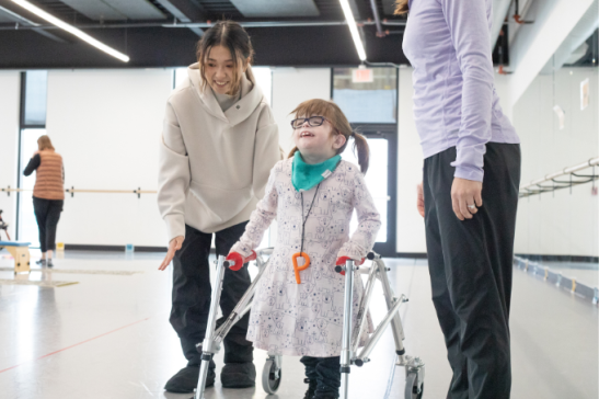 A dancer works with a student using walking aids.