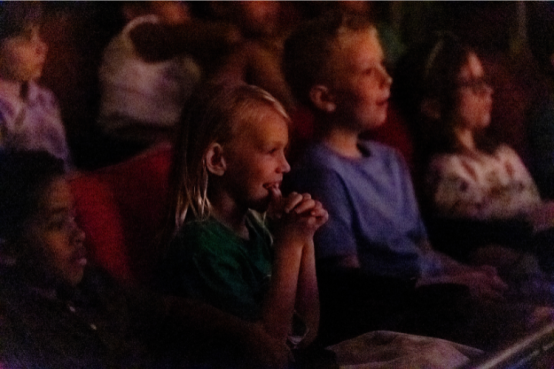 Student happily watches the performance in a theater.