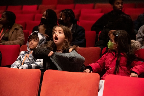 three kids sit amazed at the student matinee of The Nutcracker