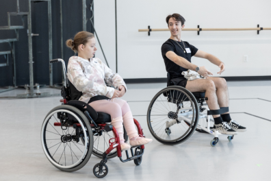 A Tour de Force student in a wheelchair learns from a dancer.