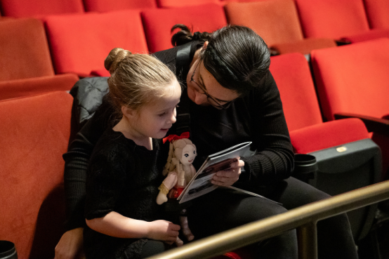 A sensory friendly girl looks at the performance program.