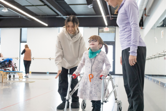 A dancer works with a student using walking aids.