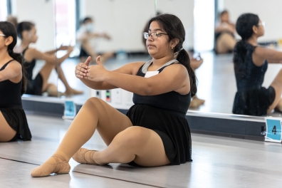 Releve student stretches in front of a mirror.