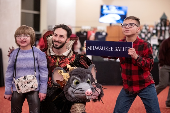 Two kids pose for a photo with a dancer from the Nutcracker at a meet and greet.