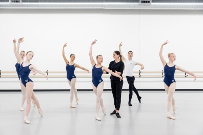 several dancers in class with instructor practice in studio.