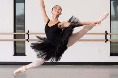 Dancer in a black tutu leaping in the air