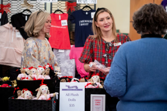 Two volunteers assist a customer at the Nutcracker Ballet Boutique