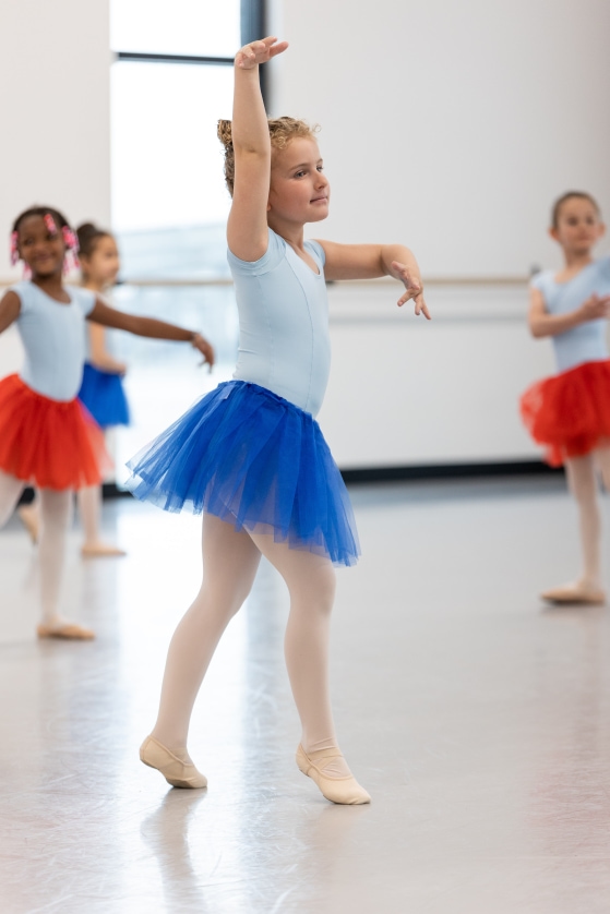 Young girl dances in blue tutu