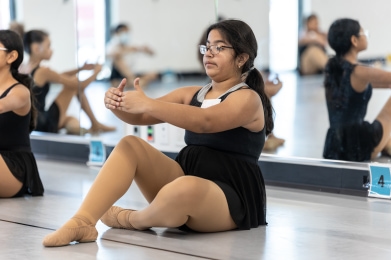 Releve student stretches in front of a mirror.