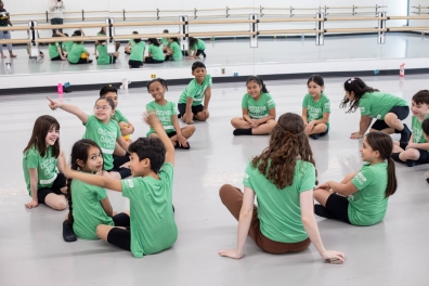 Children in green sitting in a circle