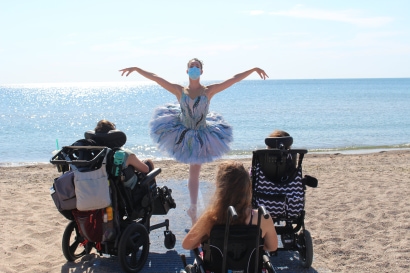 a person wearing a face mask and a ballerina on a beach